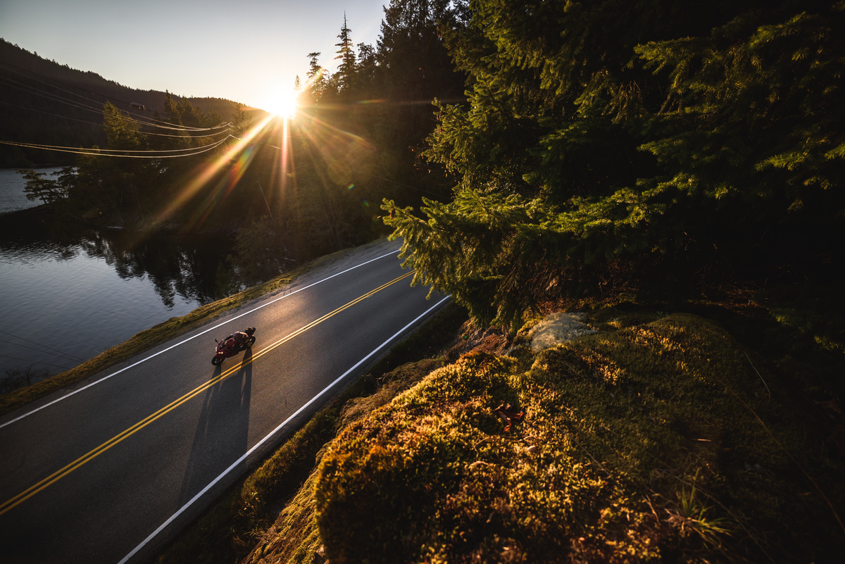 A motorcycle out for a sunset ride past Ruby Lake. There are no other vehicles on the road.