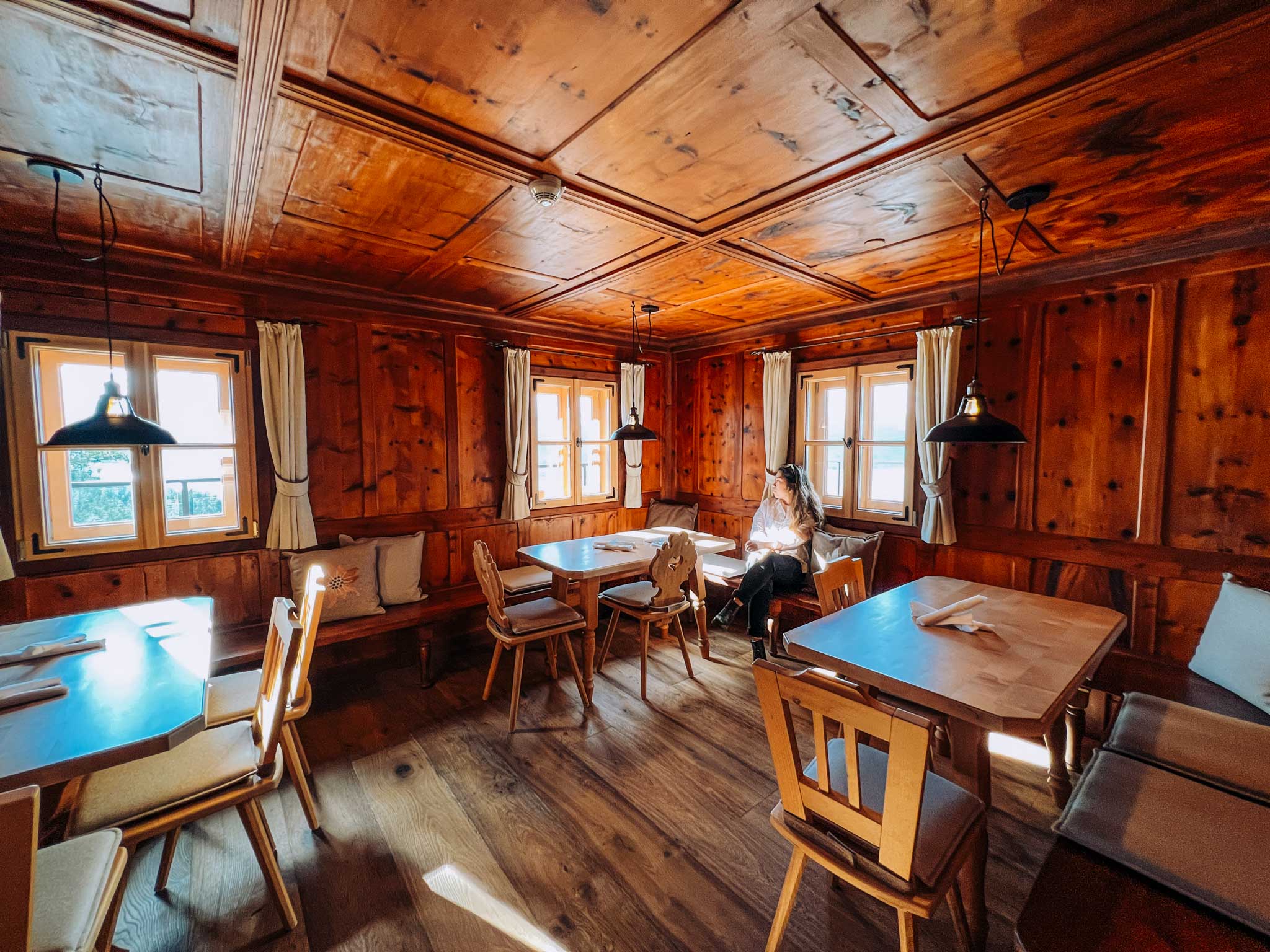 Emma Choo sits at a table in a wooden panelled room at Sparkling Hill Resort. There is sunlight coming through the windows.