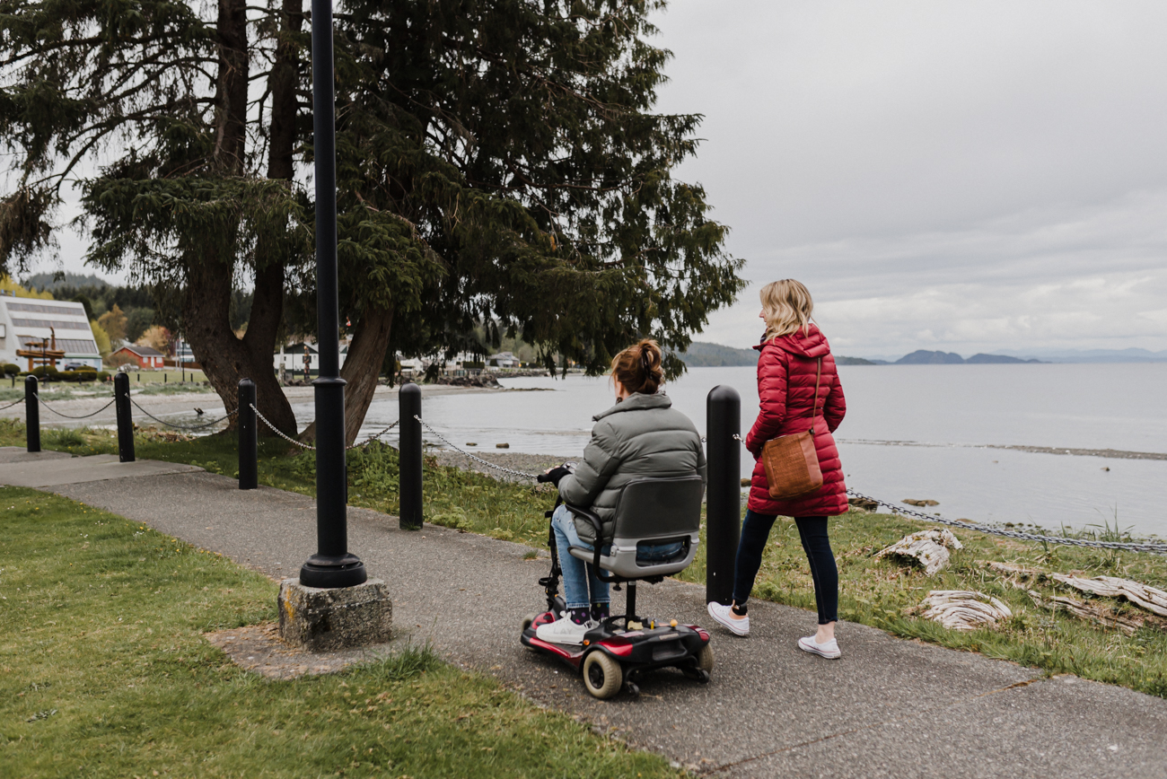 Two people, one in a wheelchair, walking along the Port Hardy waterfront | Lexa Bergen