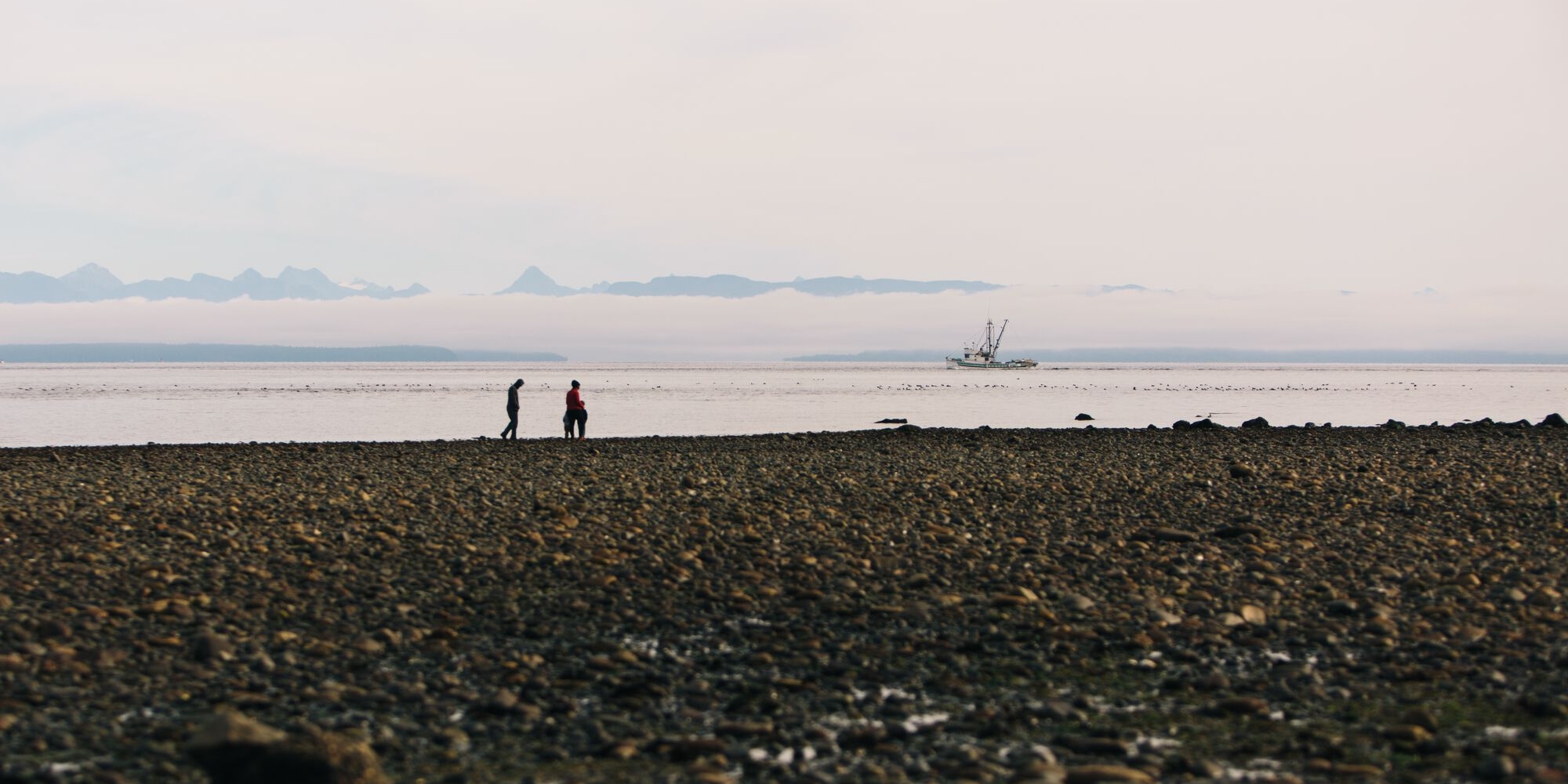 Two people walking on the beach in Campbell River | Graeme Owsianski