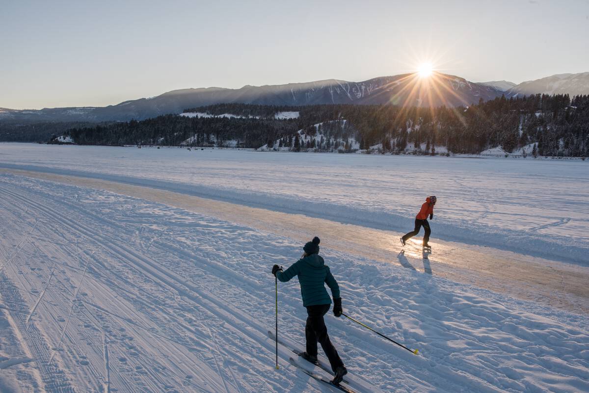 Cross-country skier and skater on the Whiteway on Windermere Lake, near Invermere BC