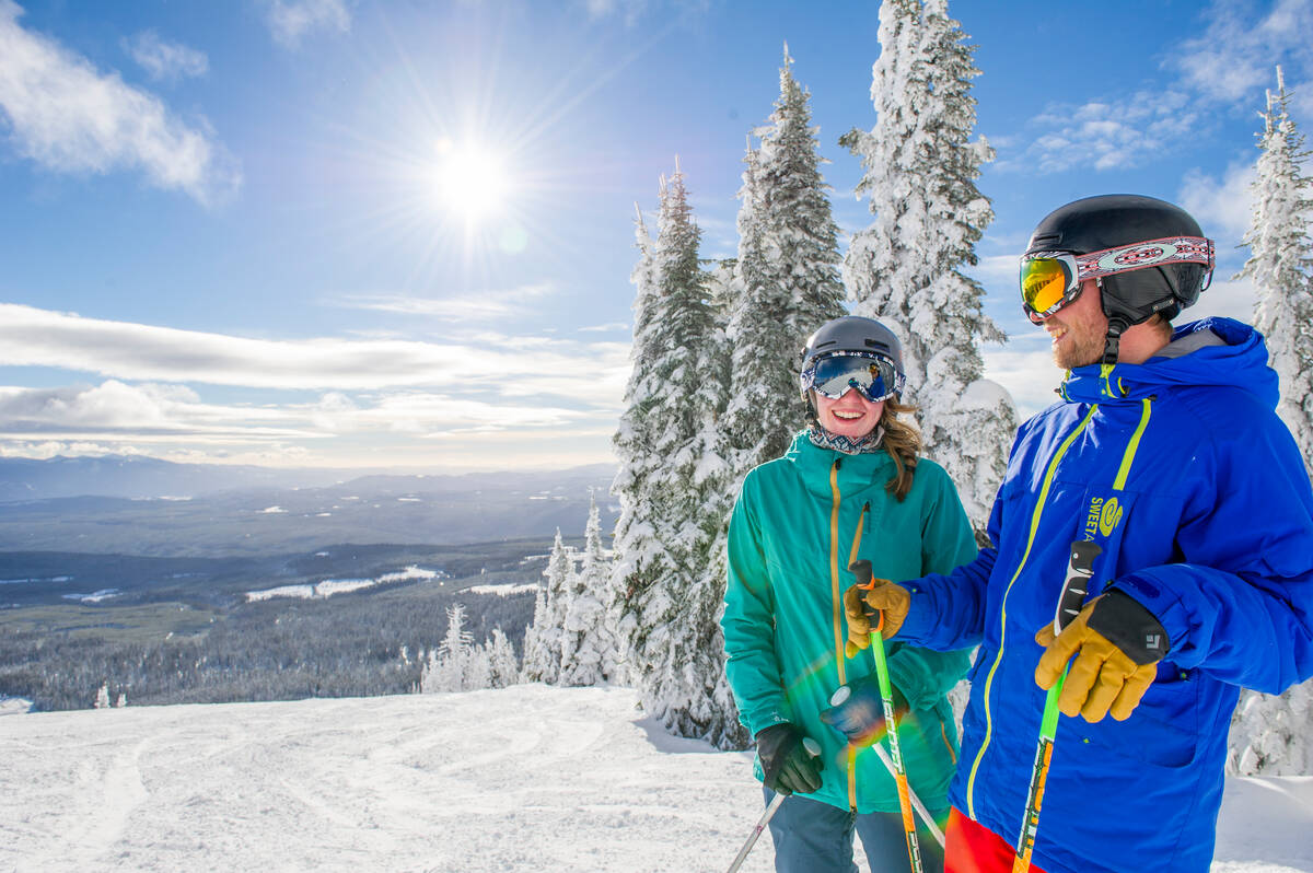 Two skiers enjoying a laugh at the top of a run at Big White Ski Resort