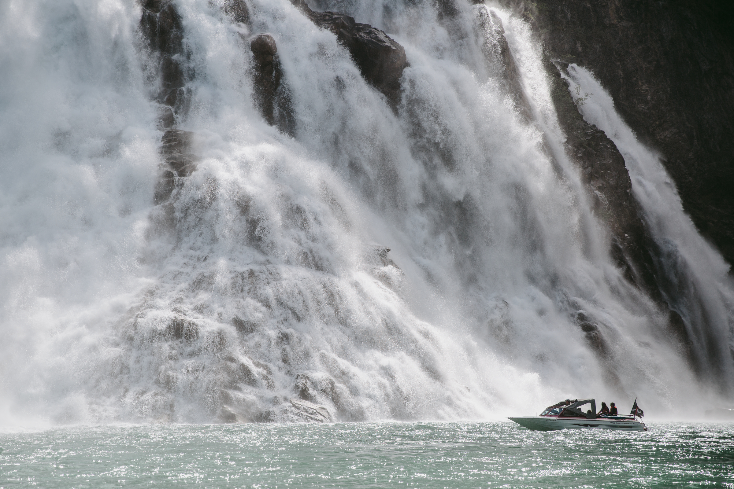 A river boat in the shadow of the towering cascades of Kinuseo Falls.